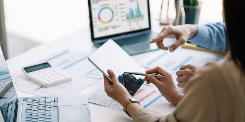 trabajadores haciendo métricas y cuentas en tableta y laptops